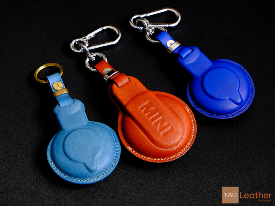 Back side of leather key fob covers for Mini Paceman in blue and orange, featuring elegant and durable craftsmanship