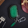 Green leather Jeep Gladiator key fob cover with embossed Jeep logo, metal keyring, and leather tag