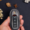 Luxury handcrafted Porsche 718 leather key fob cover for, with stitching and a keychain.