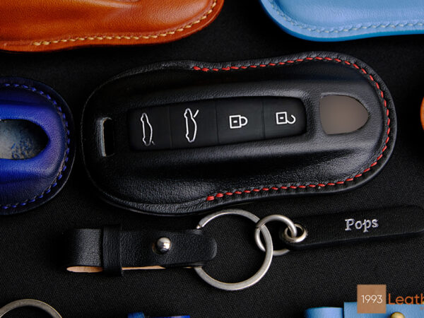 Luxury handcrafted leather key fob cover for, with stitching and a keychain.