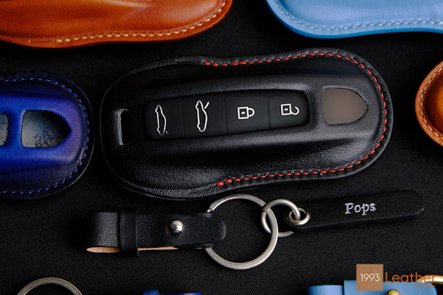 Luxury handcrafted leather key fob cover for, with stitching and a keychain.