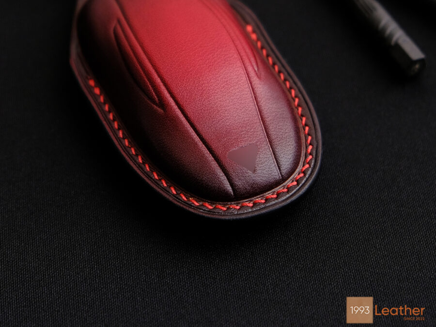 Tesla Model Y key fob cover featuring detailed, durable red hand-stitched seams.