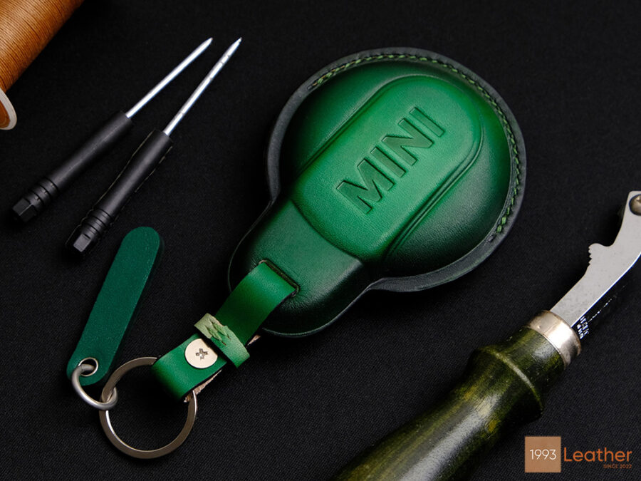 Back of Mini 5-Door key fob cover in handcrafted Patina green leather with embossed MINI logo and premium stitching.