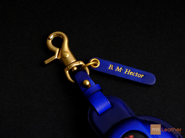 Close-up of gold hardware and blue free leather tag engraved for Mini 5-Door key fob cover.