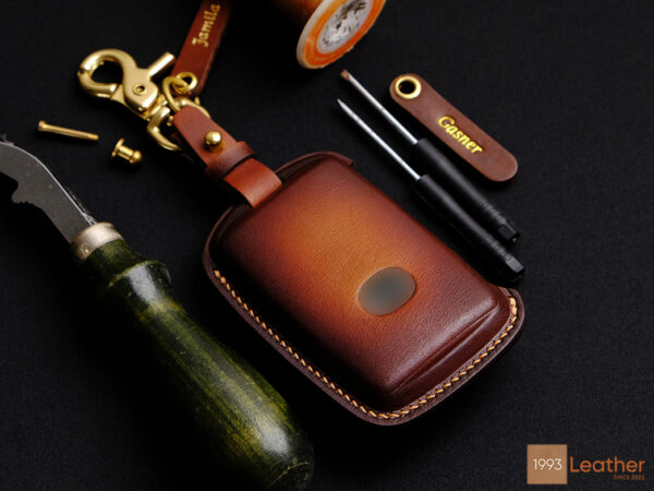 Genuine leather Mazda CX-60 key fob cover with a gradient brown finish, detailed stitching, and an elegant design.