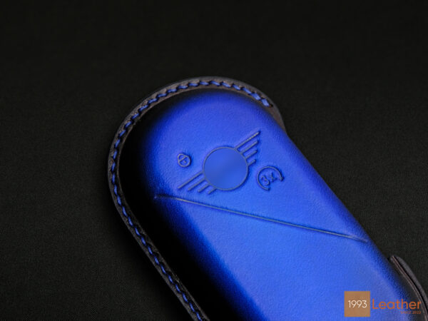 Close-up of the meticulously crafted stitching on a Patina Blue Mini Aceman key fob cover