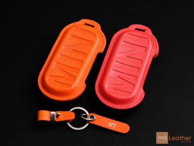 Back view of the orange and red Mini Cooper SE key fob covers with clean stitching and embossed MINI logo.