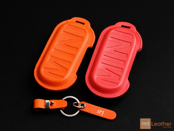 Back view of the orange and red Mini Cooper SE key fob covers with clean stitching and embossed MINI logo.