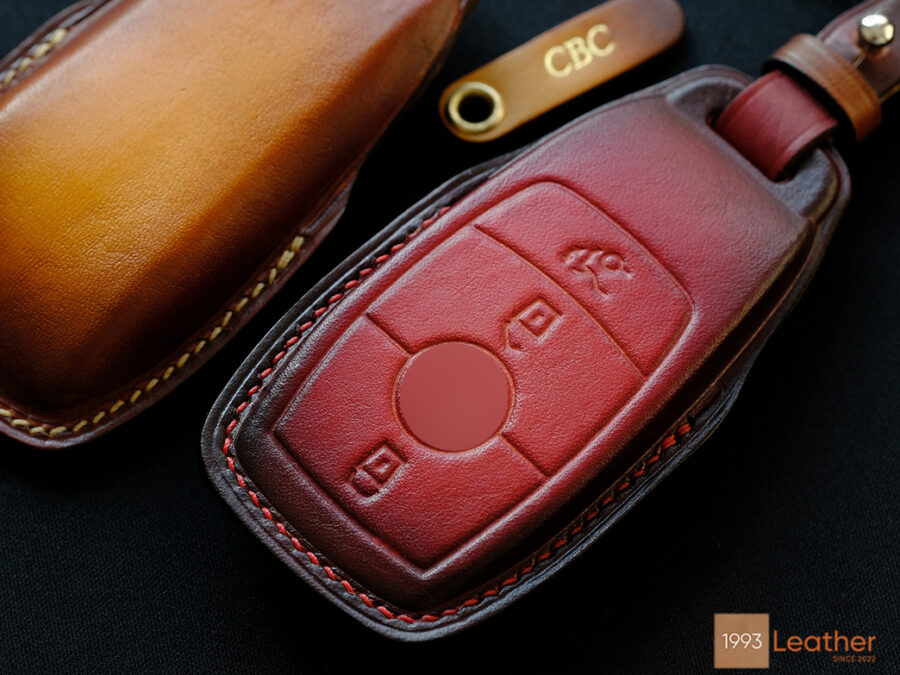 Close-up of a Mercedes E-Class key fob cover made of premium veg-tanned leather, featuring exquisite stitching and a luxurious design.