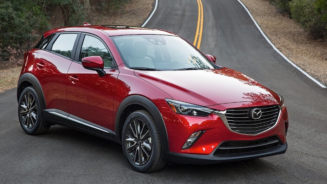 Mazda 2 in a sleek, modern design with a vibrant red exterior, showing its dynamic front grille and stylish alloy wheels.