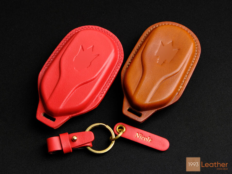 The handcrafted leather key fob case features an embossed logo design.