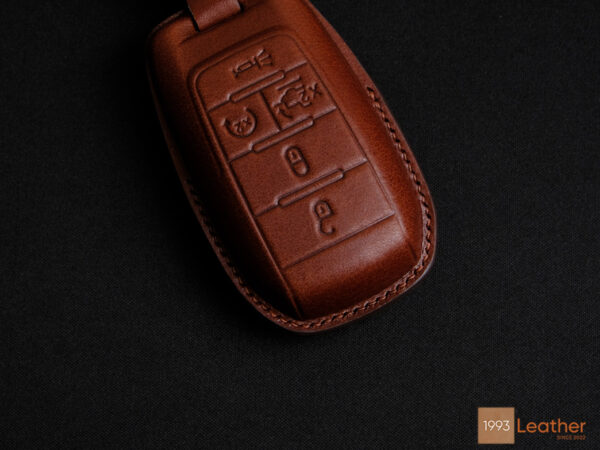 Close-up of a RAM 1500 leather key fob cover featuring fine stitching and elegant craftsmanship.