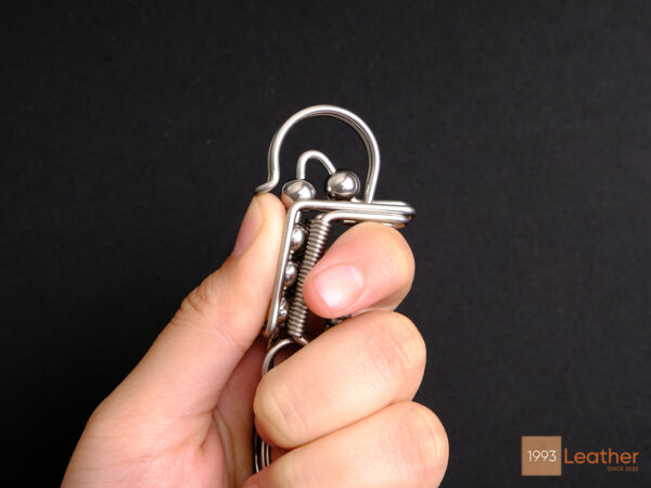 Close-up of a stainless steel keychain with a durable locking system held in hand.