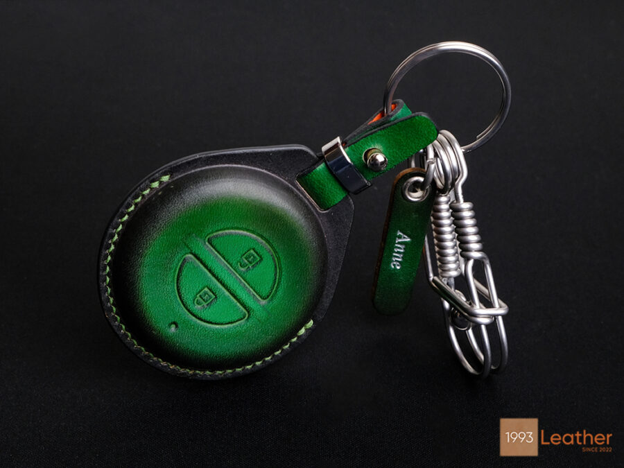 Leather key fob cover with a stainless steel keychain and engraved tag.