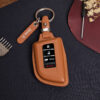 Leather Acura ZDX key fob cover in brown with metal keyring and engraved leather tag displayed on dark background