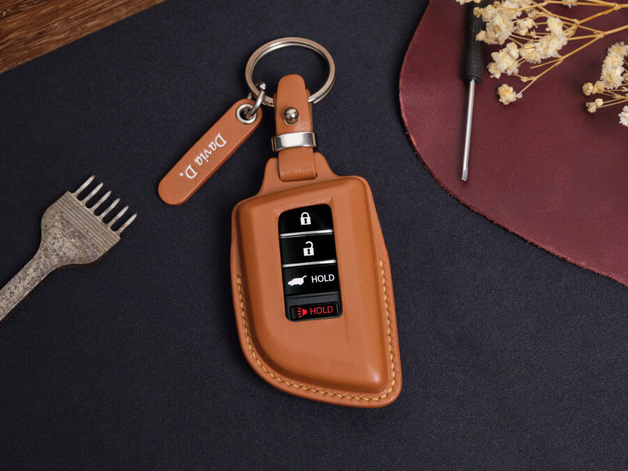 Leather Acura ZDX key fob cover in brown with metal keyring and engraved leather tag displayed on dark background