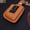 Close-up of leather Acura ZDX key fob cover showing button layout and stitched edges