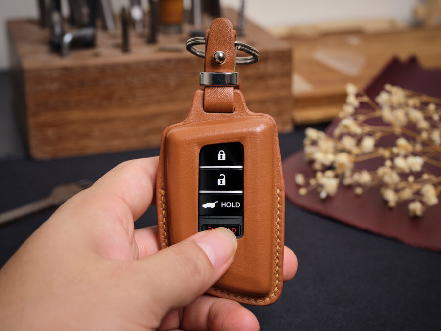 Leather Acura ZDX key fob cover held in hand showing button layout and stitched edges