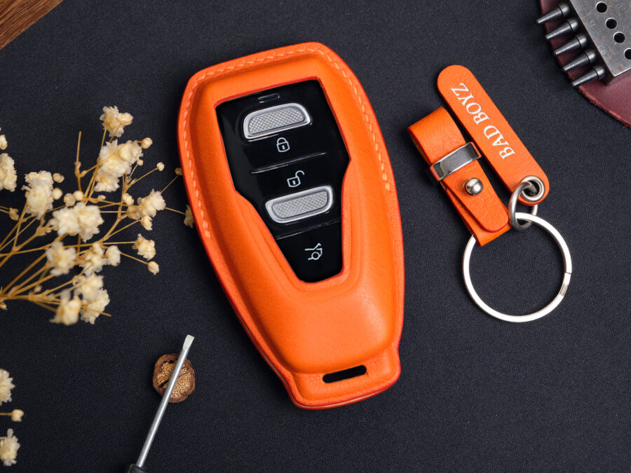 Orange leather Aston Martin DBX key fob cover with metal keyring and engraved leather tag