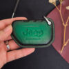 Green leather Jeep Gladiator key fob cover with embossed Jeep logo held in hand