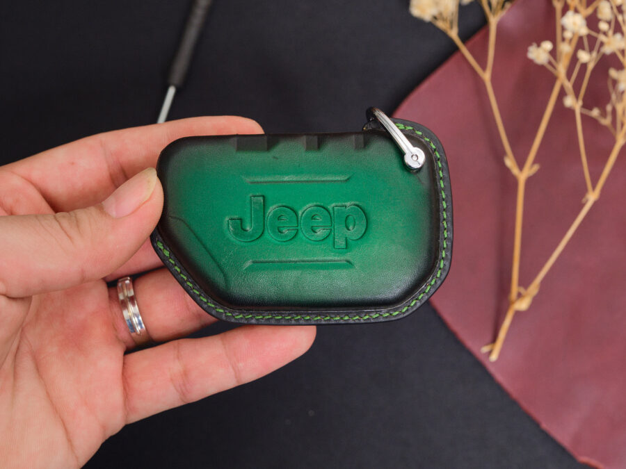 Green leather Jeep Gladiator key fob cover with embossed Jeep logo held in hand