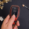 Leather Mercedes S-Class key fob cover held in hand showing button layout and contrast stitching