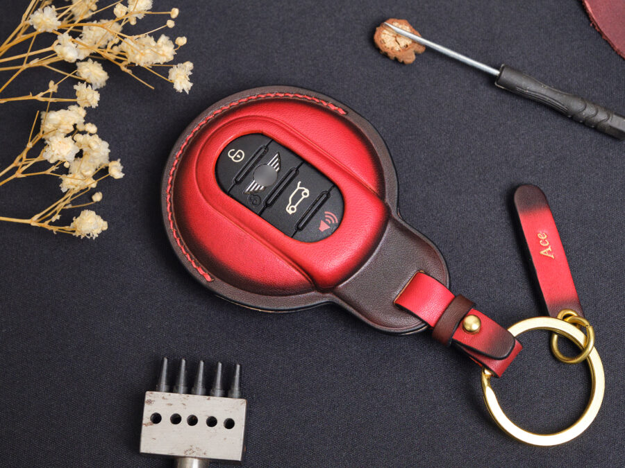 Red leather key fob cover front view showing button layout with contrast stitching