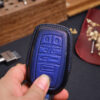 Blue leather Toyota Sequoia key fob cover held in hand showing button layout and stitched edges