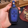 Blue leather Toyota Sequoia key fob cover with embossed logo held in hand showing stitched edges