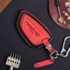 Red leather Toyota Supra key fob cover with embossed Supra logo, metal keyring, and matching leather tag