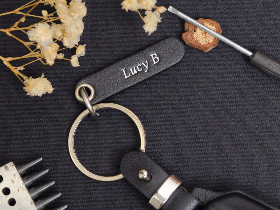 Luxury leather key fob cover for Aston Martin DB12 featuring a complimentary engraved tag and four top-quality hardware choices for a personalized touch.