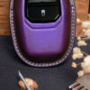 Purple leather Aston Martin Vantage key fob cover close-up showing button area and stitched edges