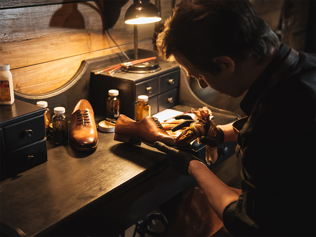 A man is caring for leather shoes by special cream