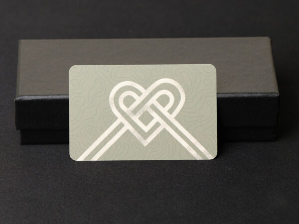 A heart shaped by a ribbon bow gift card is in front key fob cover box gift