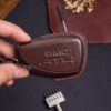 Leather GMC Sierra key fob cover with embossed GMC logo held in hand showing stitched edges