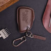 Leather GMC Sierra key fob cover with embossed GMC logo, metal keyring, and leather tag on dark surface