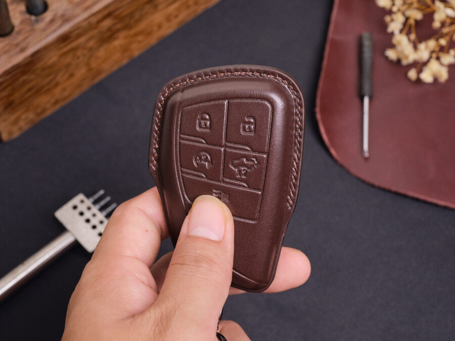Leather GMC Sierra key fob cover held in hand showing precise button cutouts and stitched edges