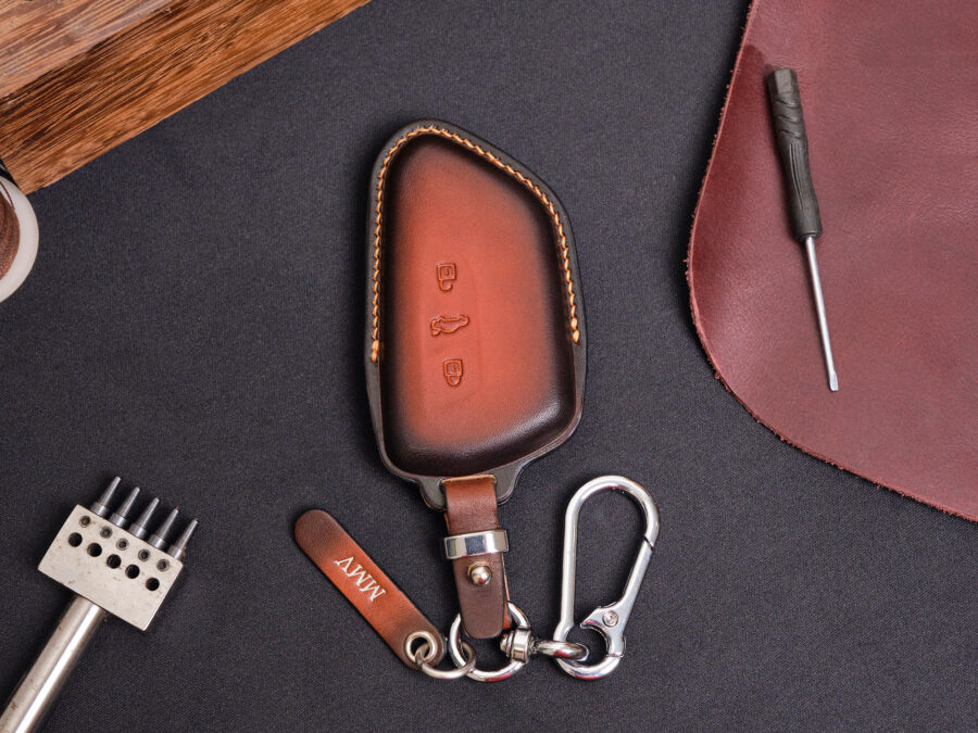 Leather Volkswagen ID key fob cover with matching keyring and leather tag displayed on dark background