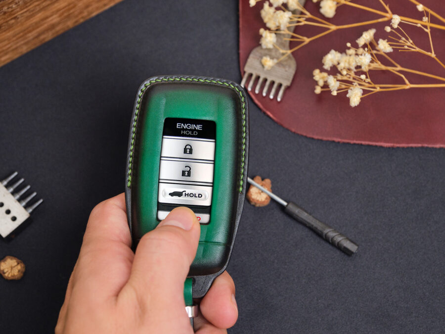 Leather Acura ADX key fob cover held in hand showing button layout and stitched edges