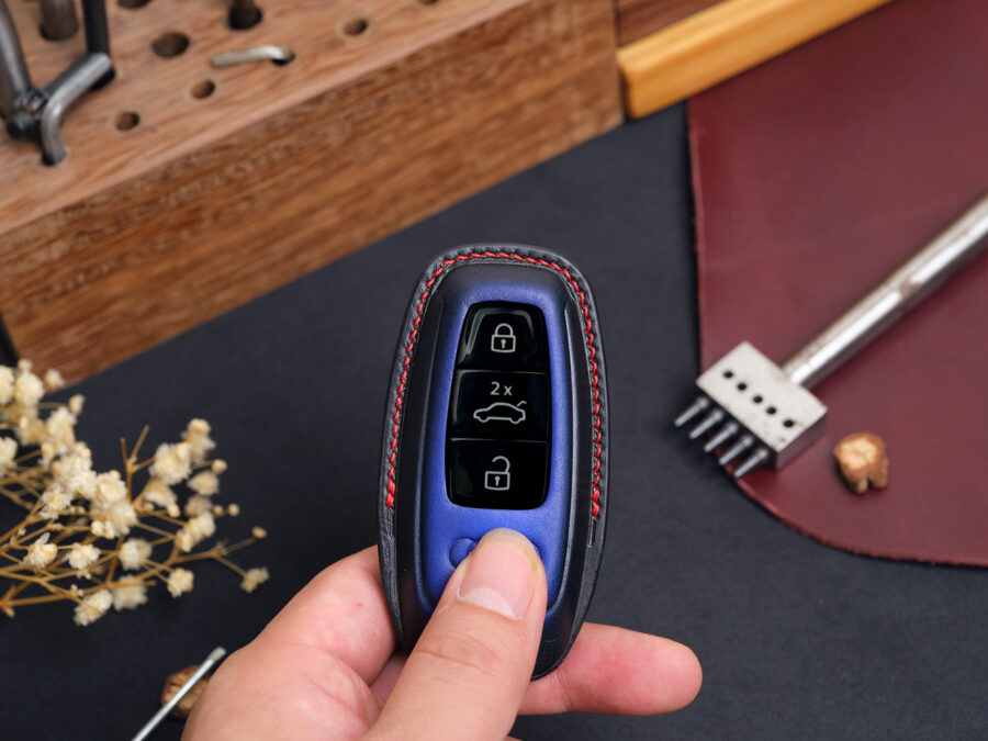 Leather Audi Q-Series key fob cover held in hand showing button layout and contrast stitching