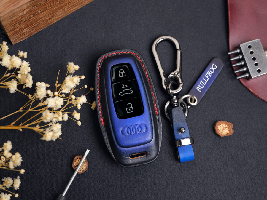 Leather Audi Q-Series key fob cover with metal keyring and engraved leather tag displayed on dark background