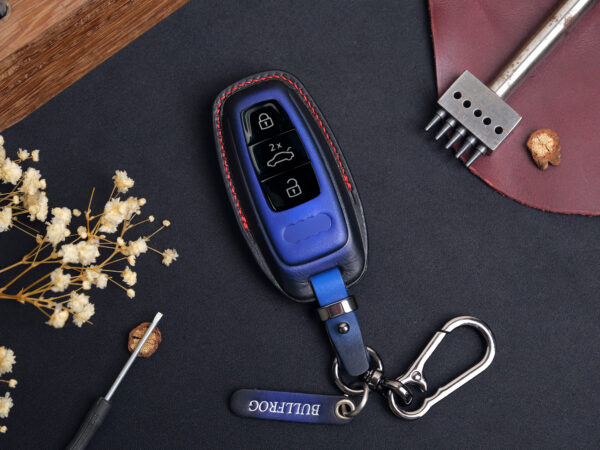 Leather Audi Q-Series key fob cover with metal keyring and engraved leather tag displayed on dark background